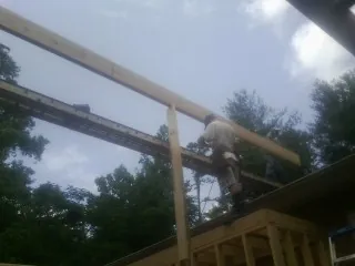 Carpenter setting a ridge beam over a new addition frame — Ice Dam Removal by Roofing Brothers in Hibernia