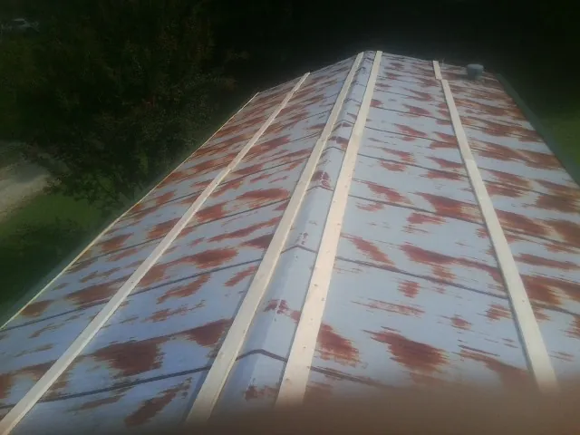 Rusted metal roof panels with new wood purlins before replacement — Storm Damage Roof Repair in Hibernia by Roofing Brothers