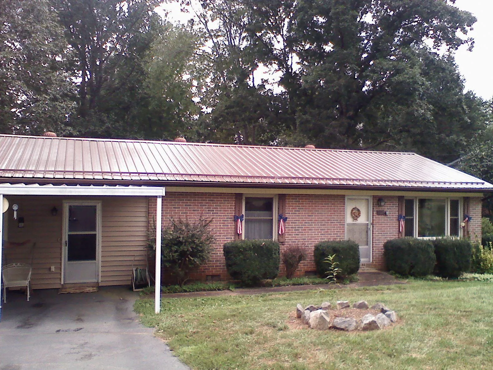 Bronze metal roof and carport on a brick ranch home — Roof Repair work by our crew in Hibernia